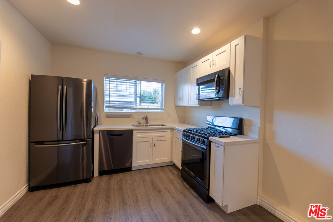 20102 Baltar Street Winnetka, CA 91306 - Photo 8 of 18 a kitchen with a refrigerator stove and wooden floor