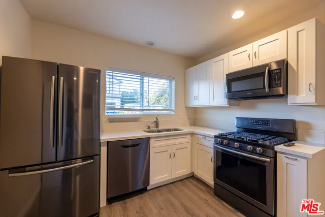 a kitchen with stainless steel appliances a refrigerator stove and microwave
