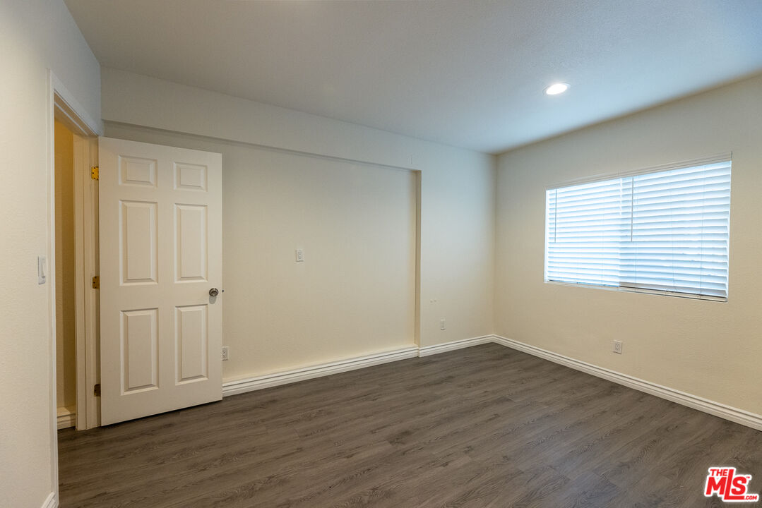 20102 Baltar Street Winnetka, CA 91306 - Photo 10 of 18 a view of an empty room with wooden floor and a window