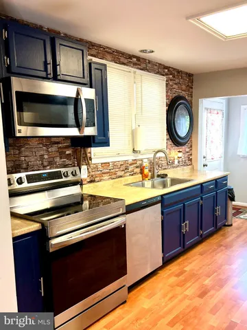 a kitchen with stainless steel appliances a stove and a microwave