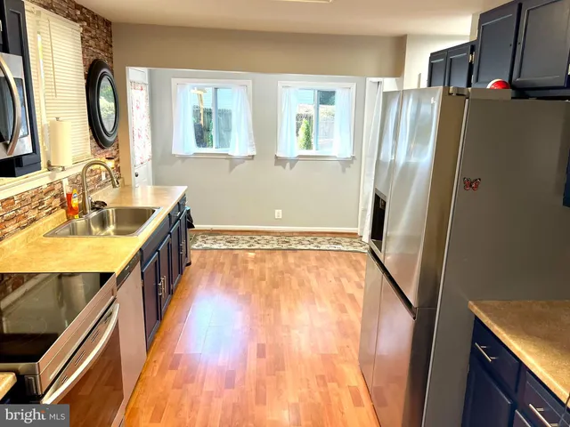 a view of a kitchen with wooden floor and a sink