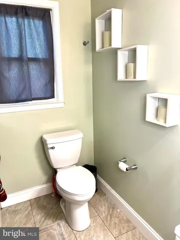 a white toilet sitting next to a wooden cabinet