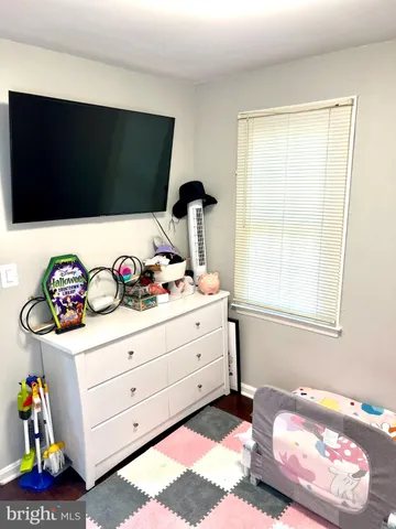 a bedroom with a bed and a flat tv screen on dresser