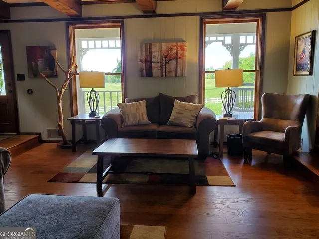 a living room with a table chairs and a chandelier