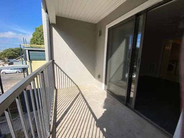 a view of balcony with wooden floor and fence