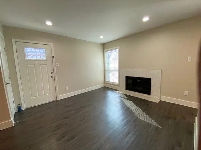 an empty room with wooden floor and fireplace