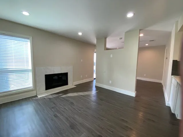 an empty room with wooden floor and fireplace