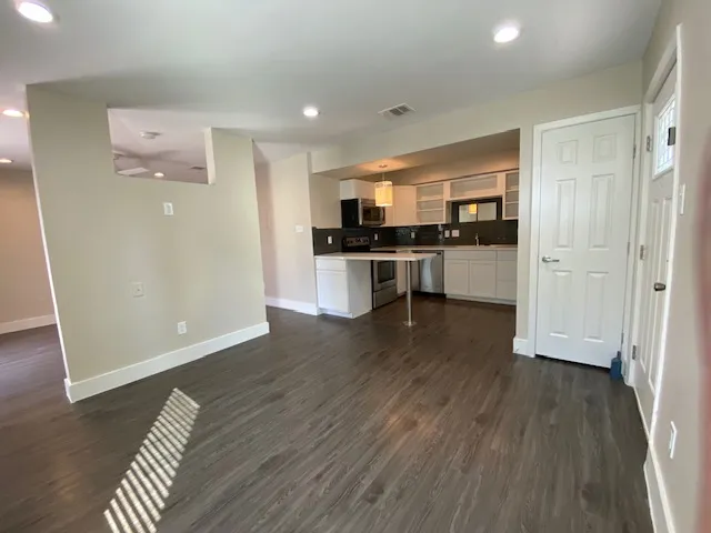 a view of kitchen with refrigerator stove and wooden floor