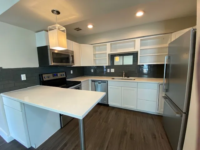 a kitchen with a sink a microwave a refrigerator and cabinets