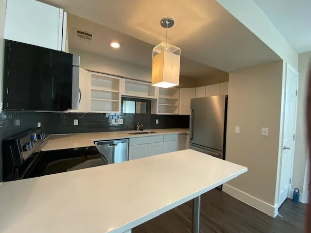 a kitchen with stainless steel appliances a refrigerator and a stove top oven
