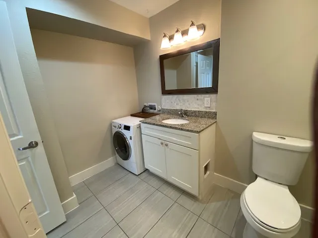 a bathroom with a toilet sink and mirror