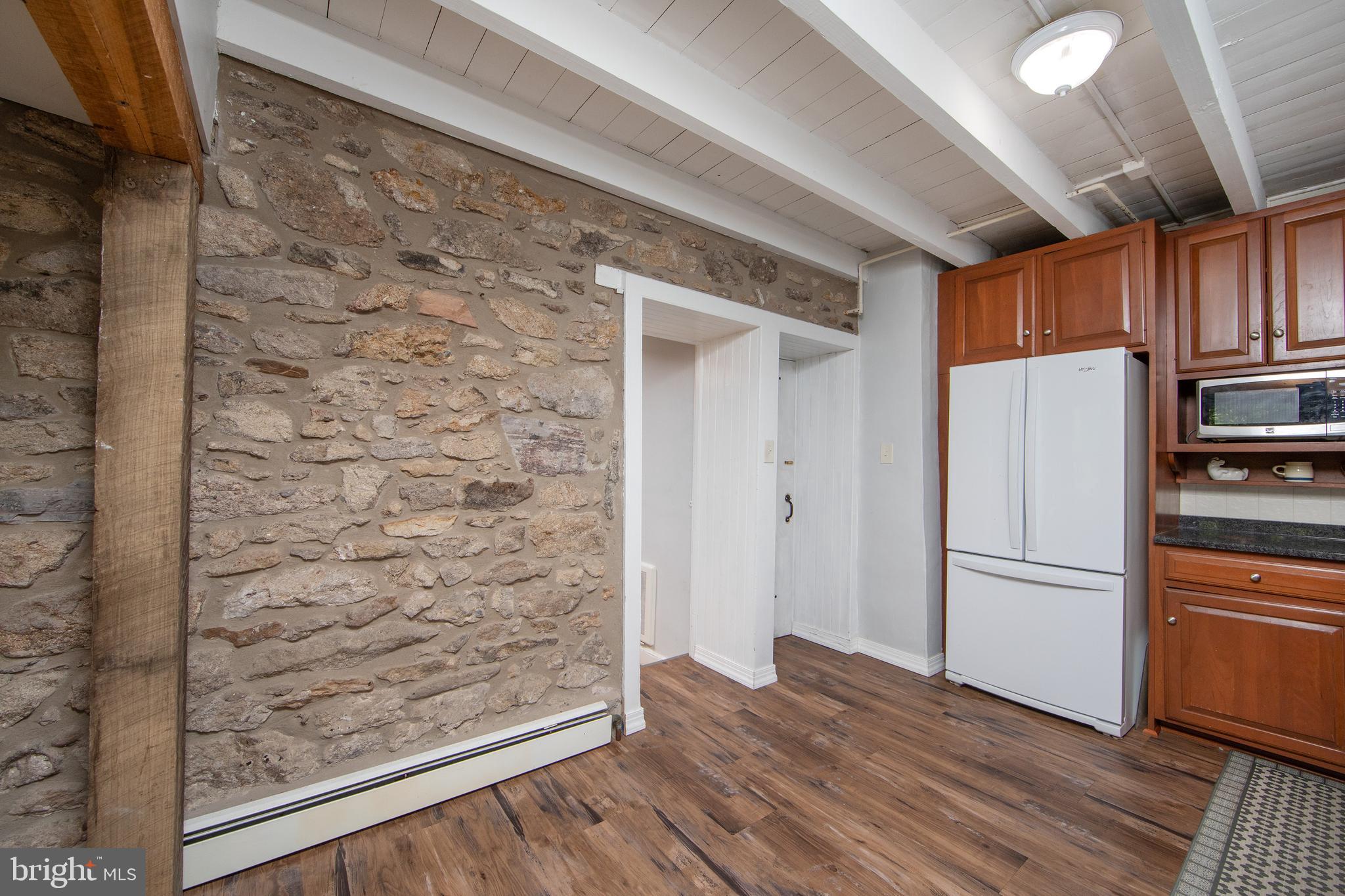 2957 River Road New Hope, PA 18938 - Photo 10 of 30 a view of a refrigerator in kitchen and an empty room with wooden floor and a window