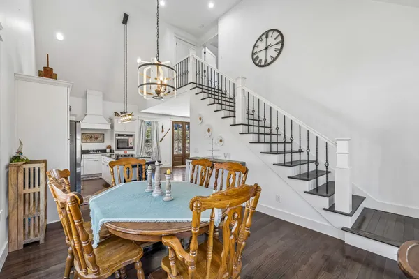 a view of a a dining room with furniture wooden floor and a chandelier