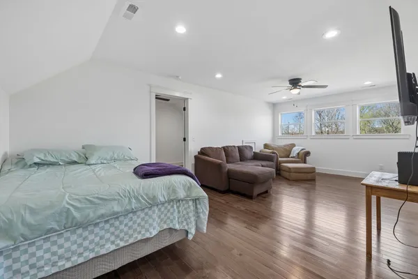 a bedroom with furniture and a wooden floor