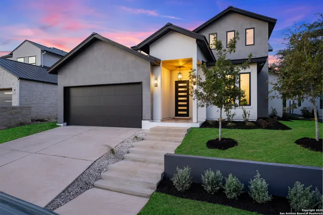 a front view of a house with a garden and plants