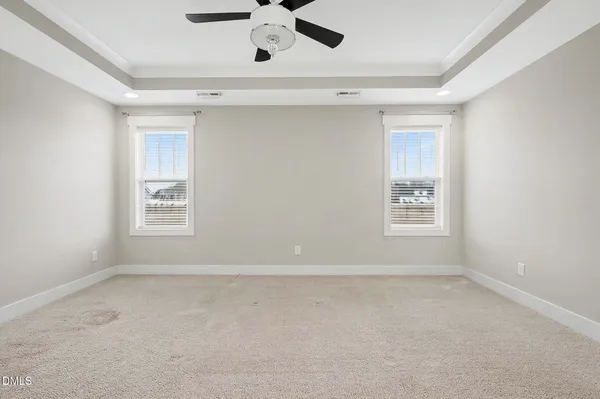 an empty room with ceiling fan and window