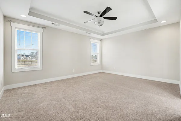 an empty room with white walls and windows