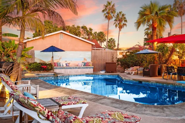 a view of a swimming pool with a table and chairs under an umbrella