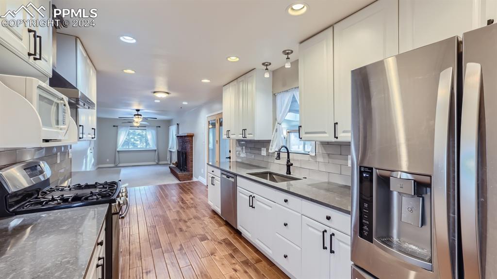 16635 High Tree Drive Elbert, CO 80106 - Photo 8 of 44 a kitchen with stainless steel appliances granite countertop a refrigerator a sink dishwasher a stove and white countertops with wooden floor