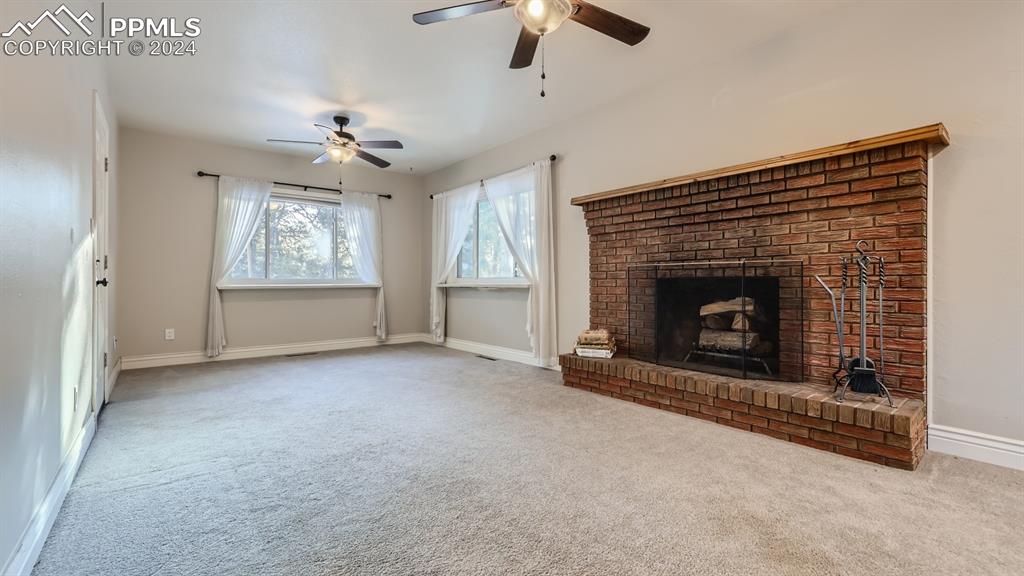 16635 High Tree Drive Elbert, CO 80106 - Photo 9 of 44 an empty room with windows fireplace and fan