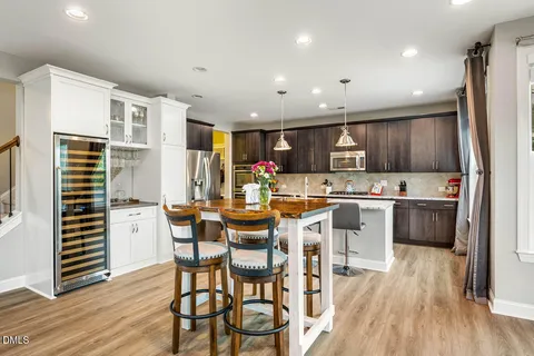 a kitchen with kitchen island granite countertop wooden floors cabinets and stainless steel appliances