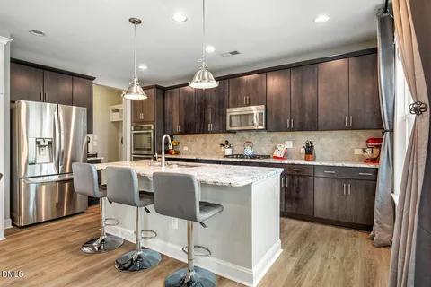 a kitchen with kitchen island granite countertop a sink cabinets and window