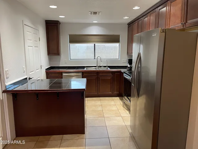a kitchen with granite countertop a refrigerator and a sink