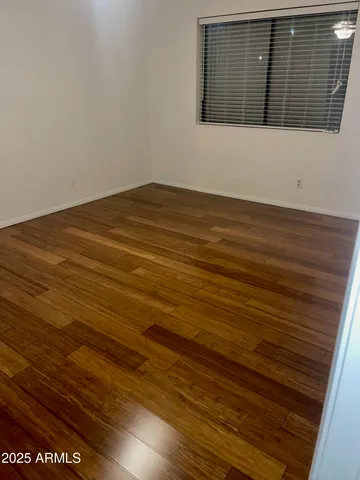 a view of room with wooden floor and bench