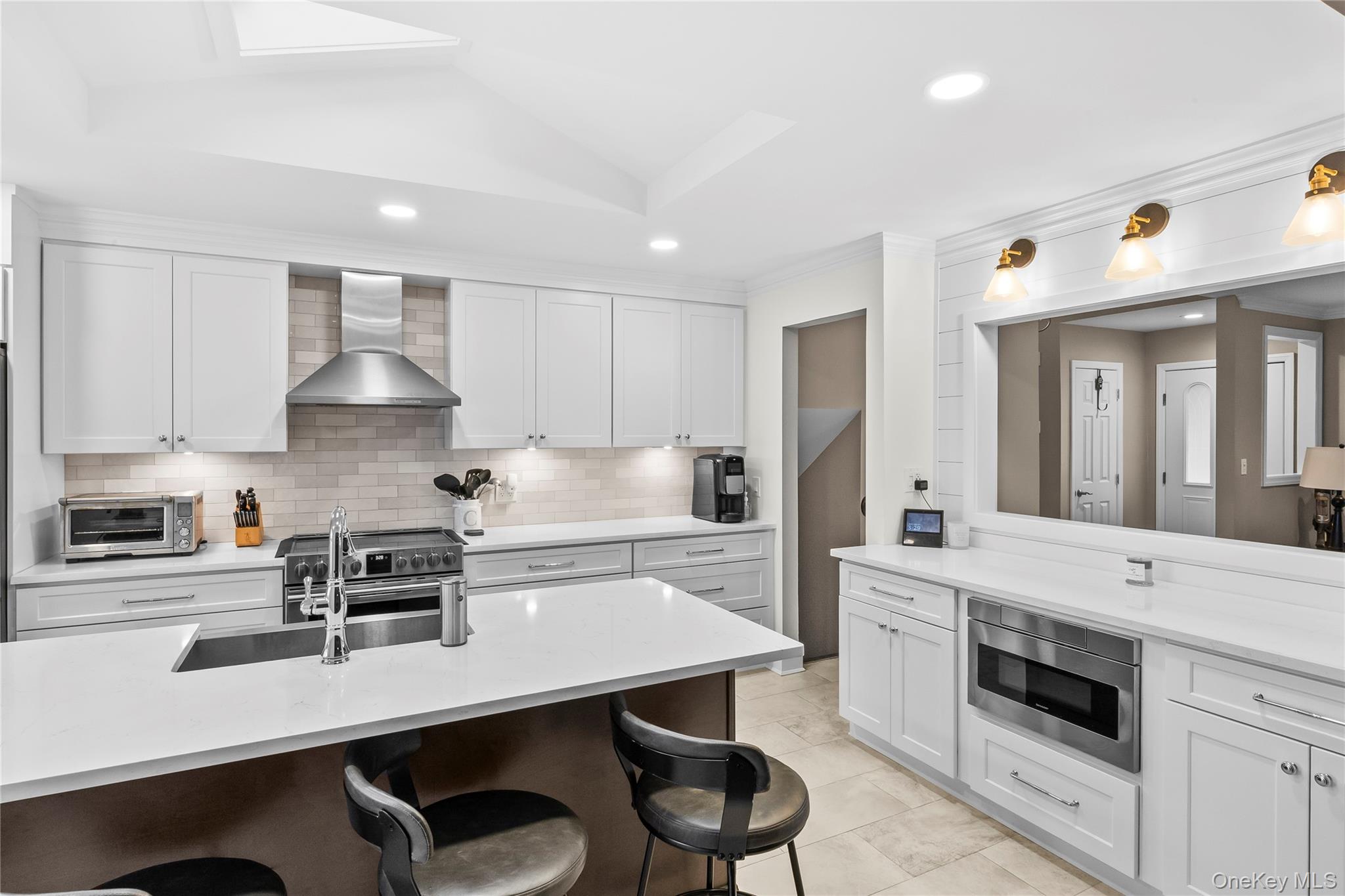 26 Glenwood Road Plainview, NY 11803 - Photo 11 of 42 a kitchen with a sink a stove a refrigerator and white cabinets