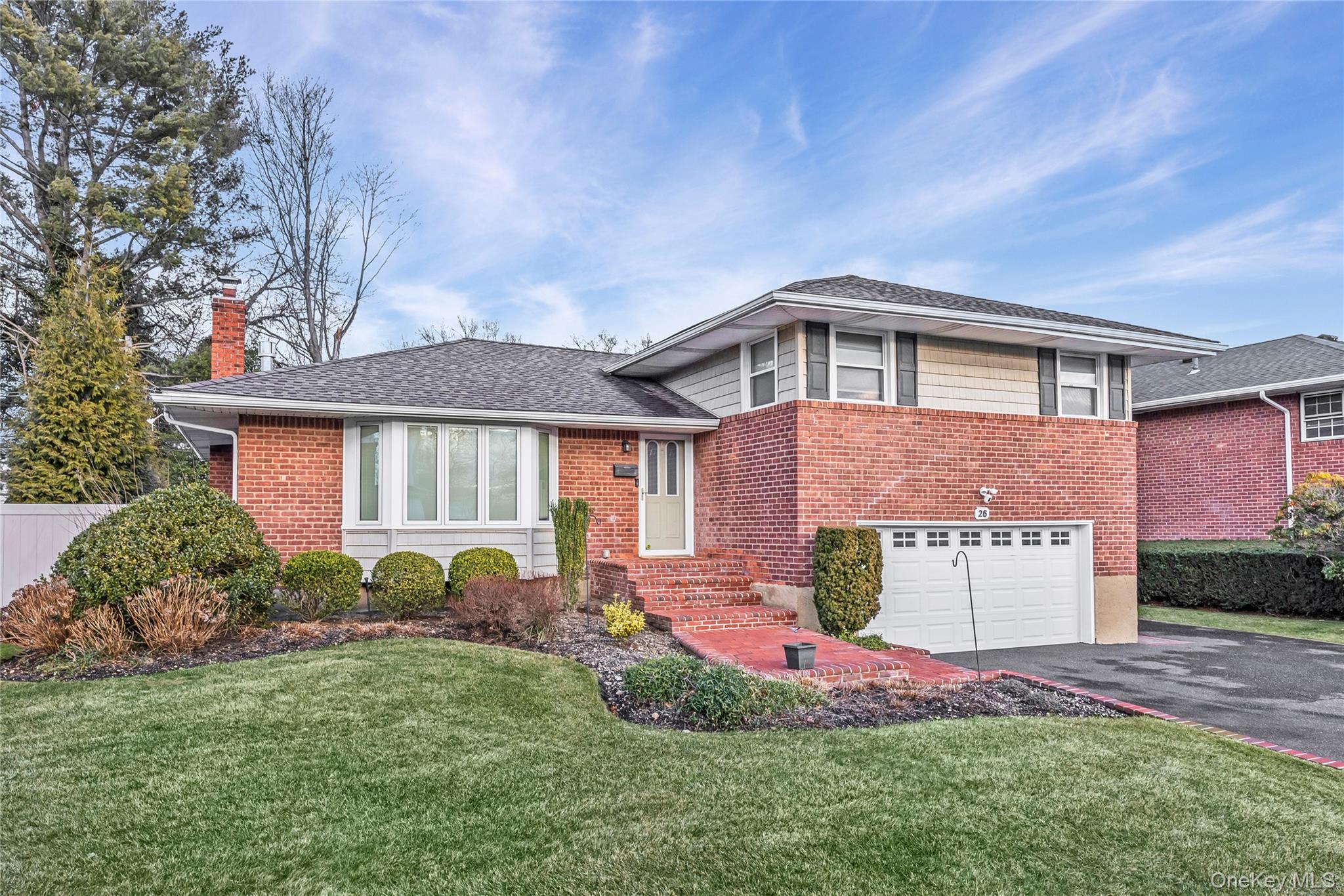 26 Glenwood Road Plainview, NY 11803 - Photo 2 of 42 a front view of a house with a yard and garage