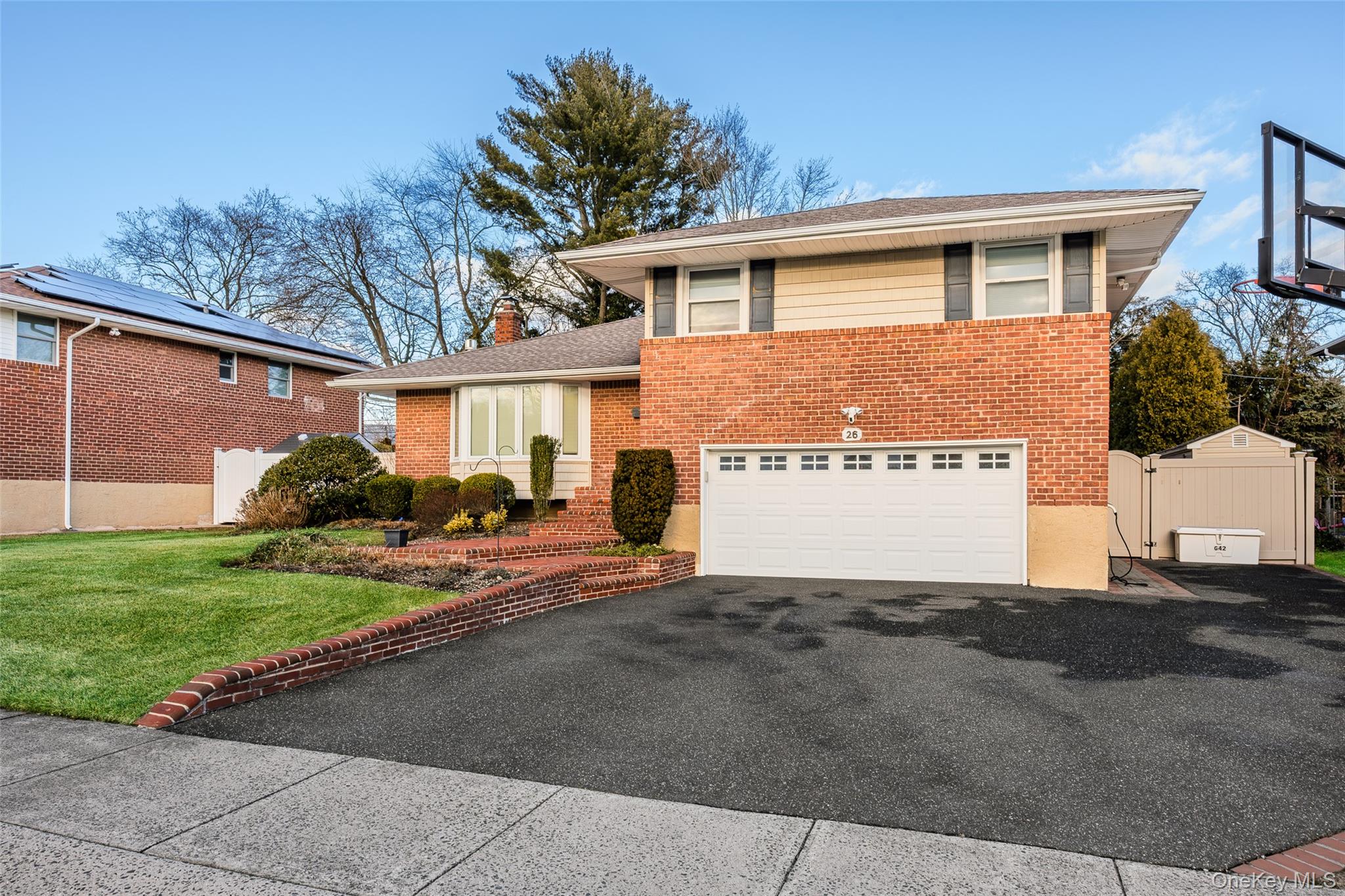 26 Glenwood Road Plainview, NY 11803 - Photo 4 of 42 a front view of a house with a yard and garage