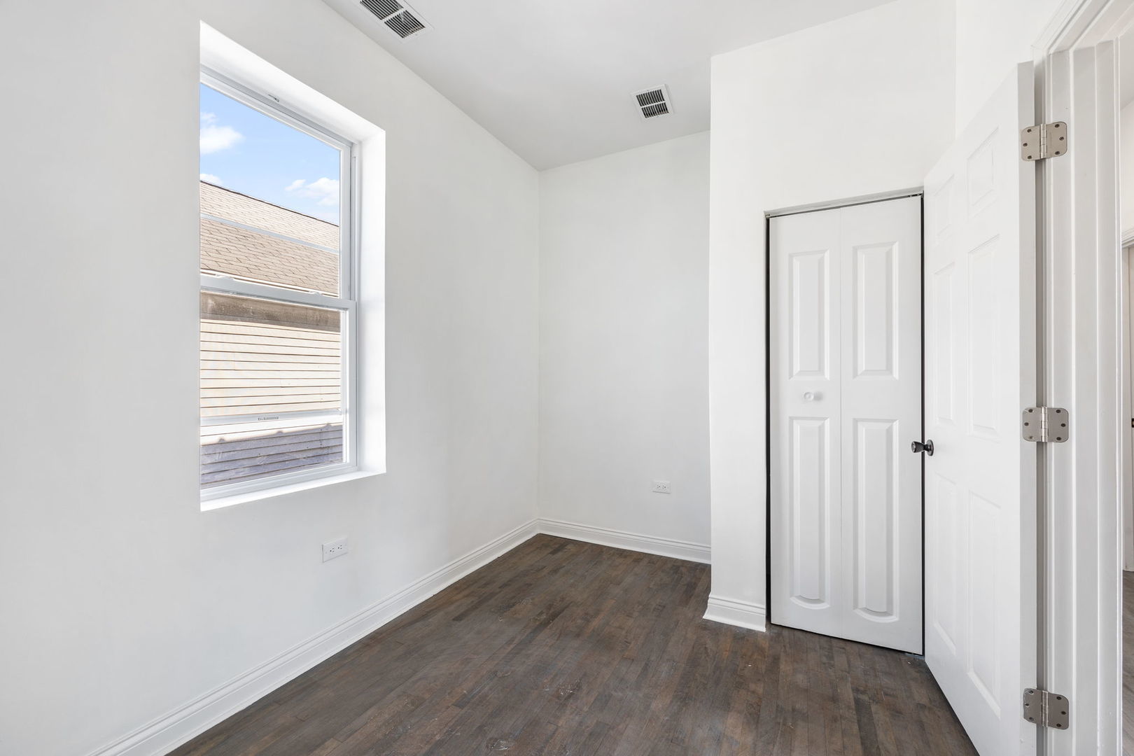 2408 South Trumbull Avenue Chicago, IL 60623 - Photo 17 of 34 an empty room with wooden floor and windows