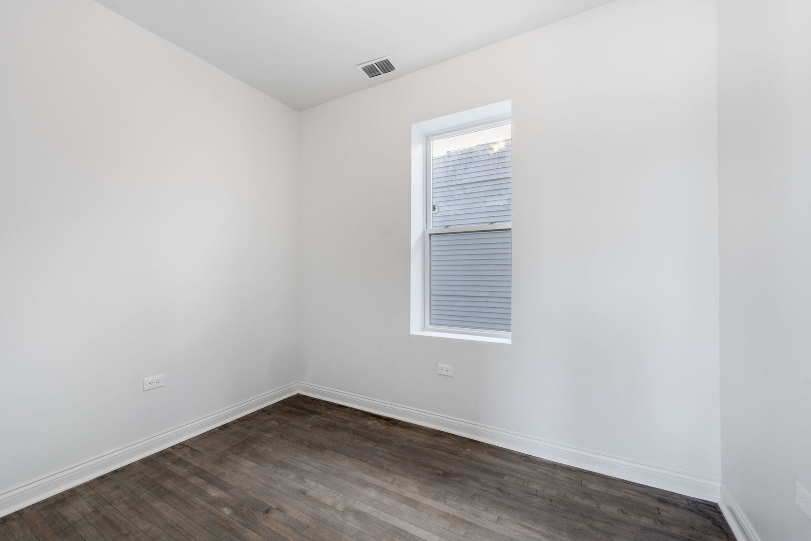 2408 South Trumbull Avenue Chicago, IL 60623 - Photo 27 of 34 an empty room with wooden floor and windows