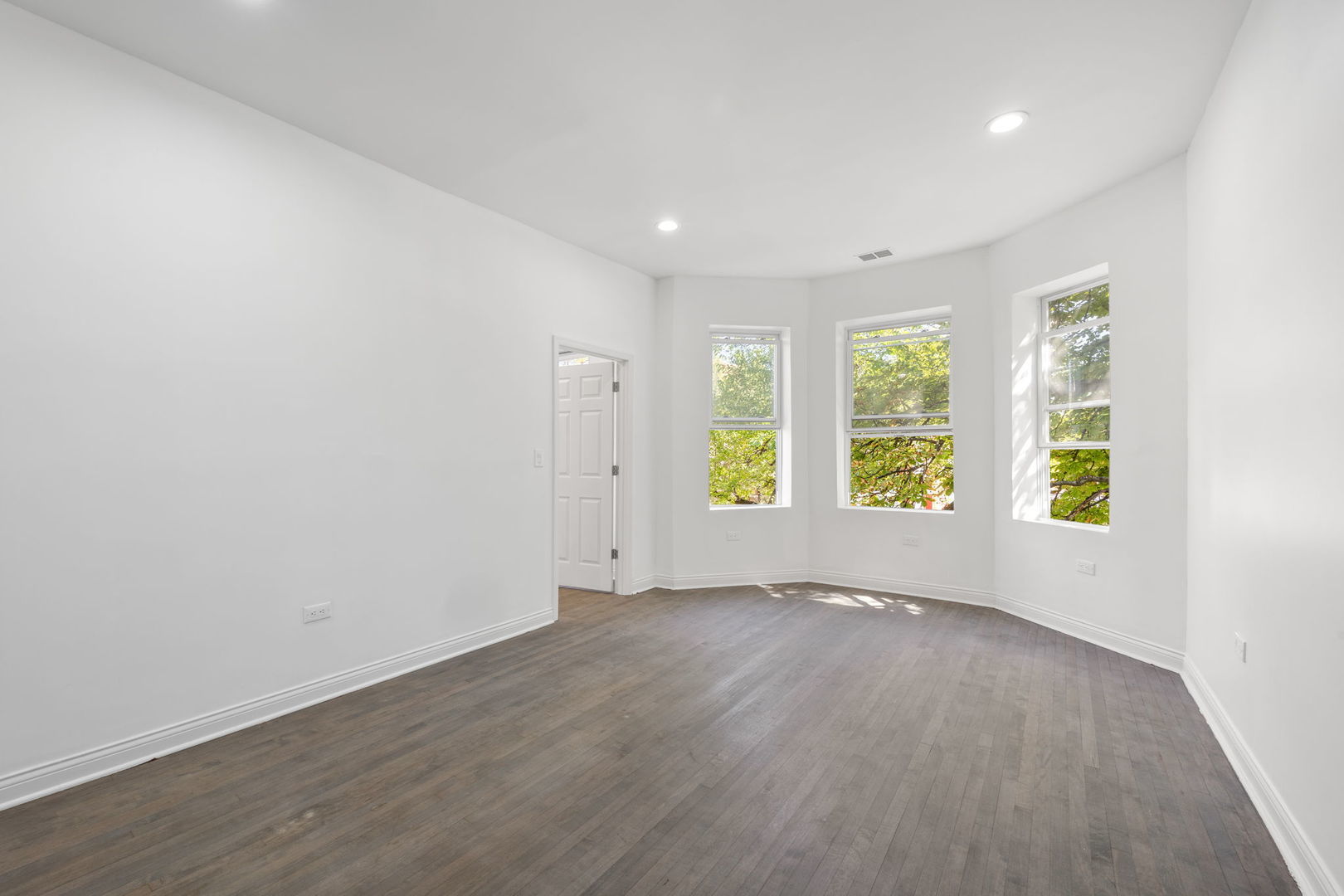 2408 South Trumbull Avenue Chicago, IL 60623 - Photo 3 of 34 an empty room with wooden floor and windows
