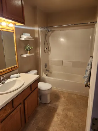 a bathroom with a granite countertop sink toilet and shower