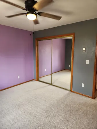 a view of an empty room with a chandelier fan
