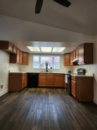 a large kitchen with stainless steel appliances wooden floors and wooden cabinets
