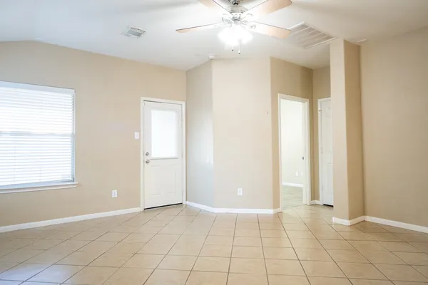 an empty room with fan and windows