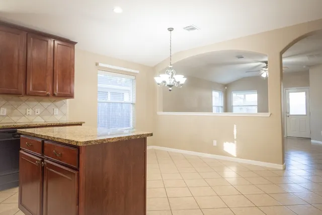 a kitchen with granite countertop a sink a counter space and cabinets