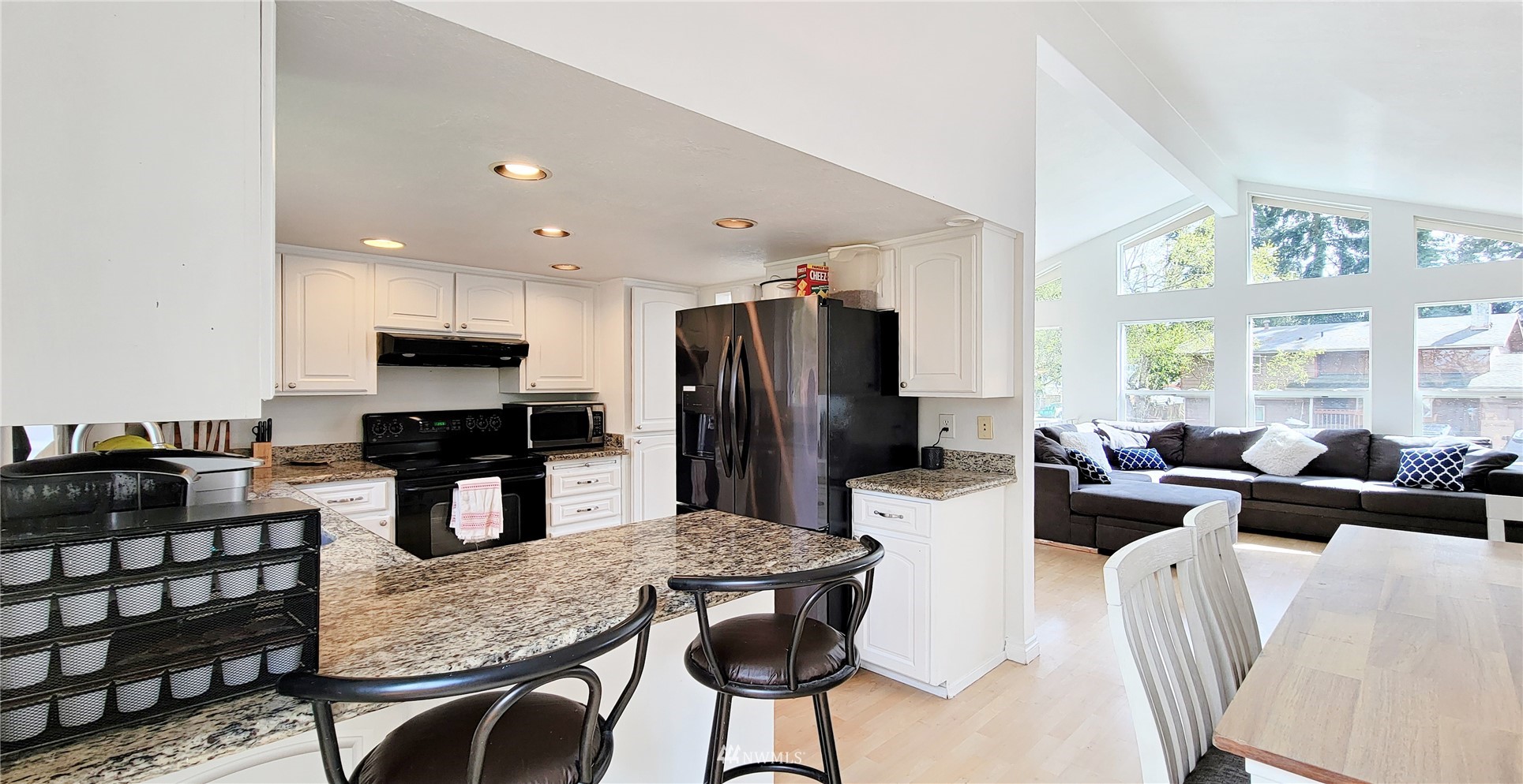 2652 Southwest 333rd Place Federal Way, WA 98023 - Photo 12 of 40 a kitchen with stainless steel appliances kitchen island granite countertop a refrigerator a stove a sink dishwasher a dining table and chairs with wooden floor