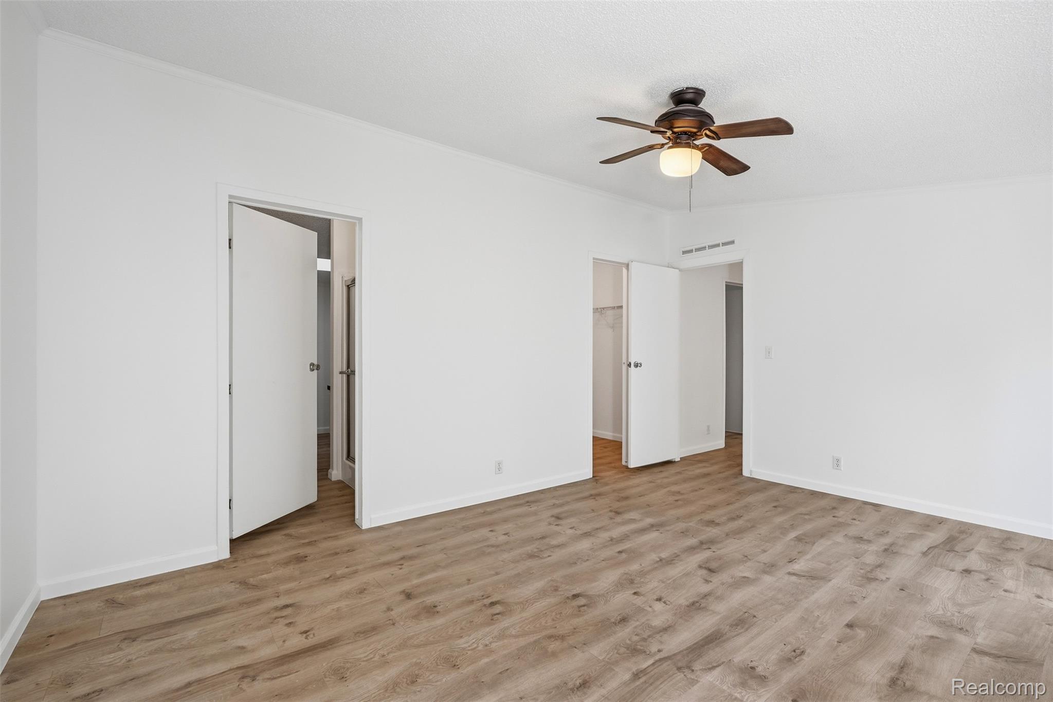 3432 Stanton Road Oxford, MI 48371 - Photo 20 of 48 Spacious interior featuring wood-finish flooring, white walls, and a ceiling fan with integrated lighting