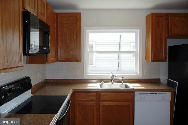 117 Spring Street Gaithersburg, MD 20877 - Photo 17 of 23 a kitchen with a sink stove and cabinets