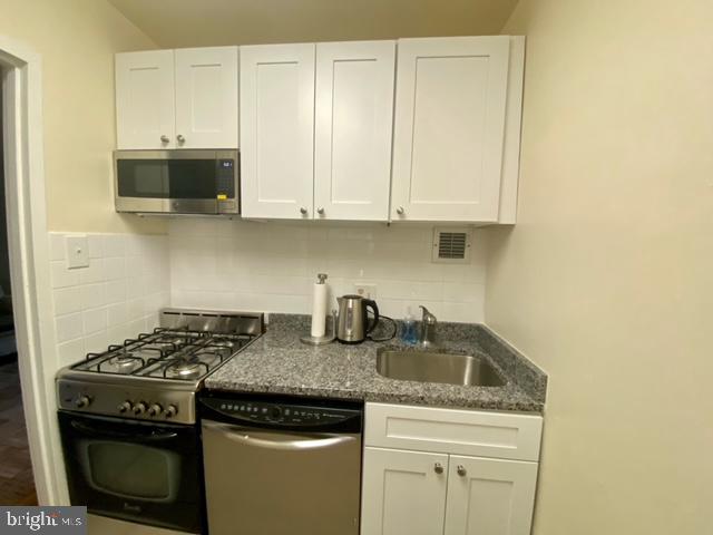 1121 Arlington Boulevard, Unit 620 Arlington, VA 22209 - Photo 11 of 33 a kitchen with granite countertop a stove sink and cabinets