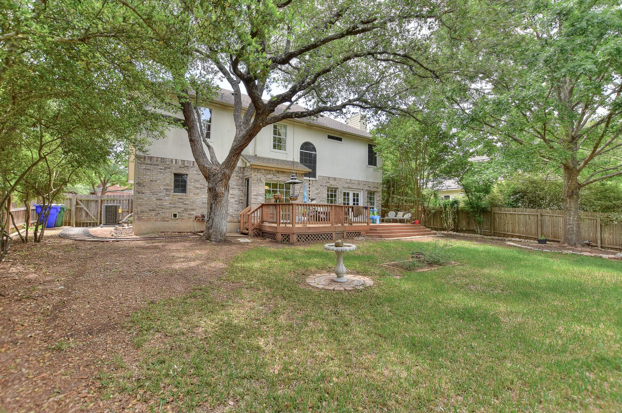 1609 Colton Way Cedar Park, TX 78613 - Photo 16 of 24 A spacious backyard features a multi-level deck, perfect for outdoor gatherings, alongside mature trees providing ample shade.