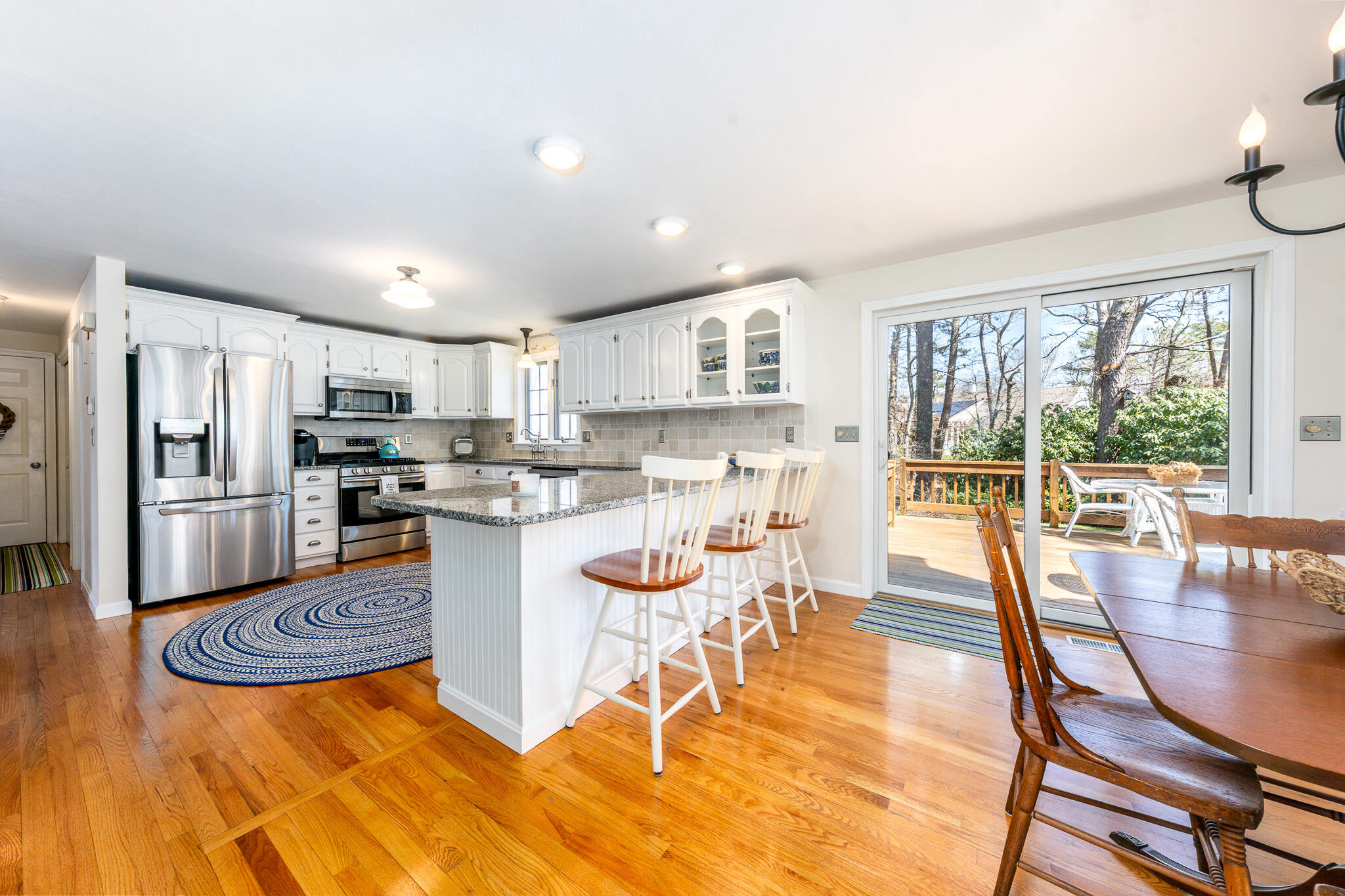 42 Eventide Lane Hyannis, MA 02601 - Photo 5 of 39 a kitchen with stainless steel appliances kitchen island granite countertop a refrigerator a stove a dining table and chairs with wooden floor