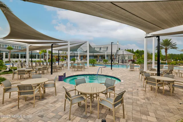 a outdoor space with lots of tables a large window and furniture