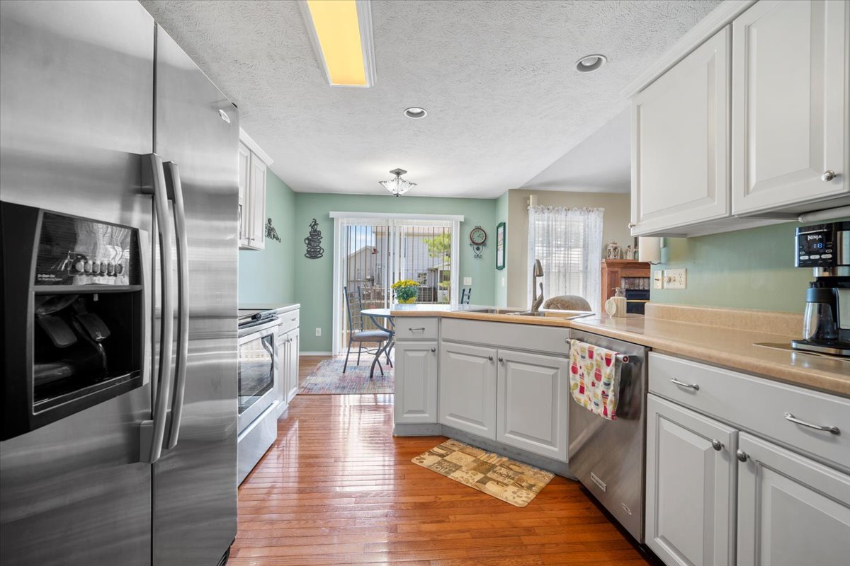 3205 Stonebridge Drive Bloomington, IL 61704 - Photo 11 of 37 a kitchen with stainless steel appliances granite countertop a refrigerator a sink dishwasher a oven with white cabinets and wooden floor