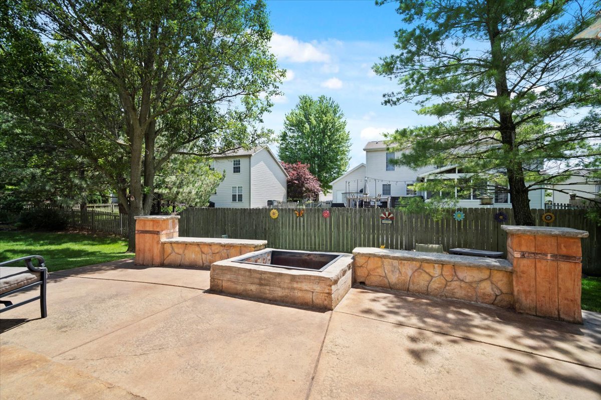 3205 Stonebridge Drive Bloomington, IL 61704 - Photo 32 of 37 a view of a patio with table and chairs potted plants and a large tree