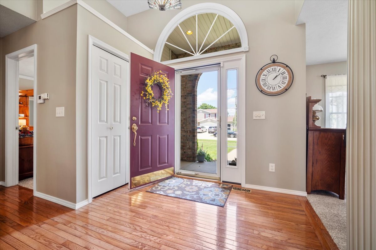 3205 Stonebridge Drive Bloomington, IL 61704 - Photo 4 of 37 a view of a hallway with entryway wooden floor and front door