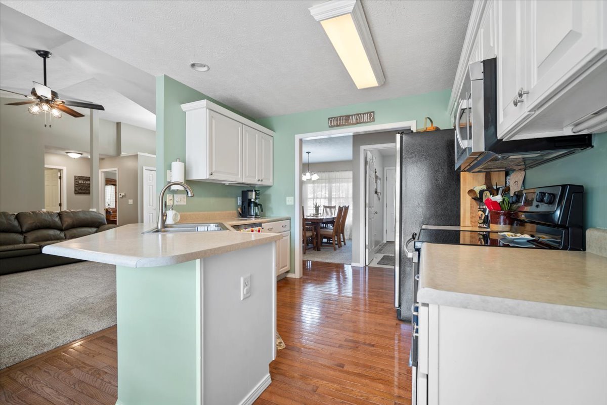 3205 Stonebridge Drive Bloomington, IL 61704 - Photo 10 of 37 a kitchen with stainless steel appliances a refrigerator a stove a sink dishwasher and white cabinets with wooden floor